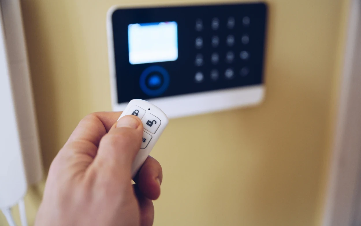 the importance of home security in melbourne Hand using remote control for security keypad
